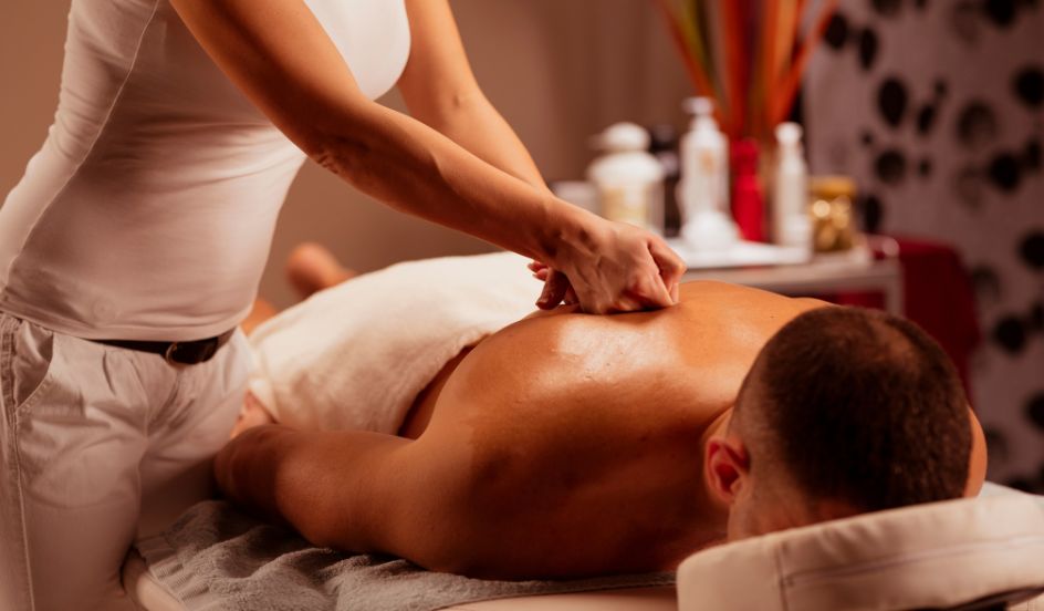 massage therapist providing a massage on a male client