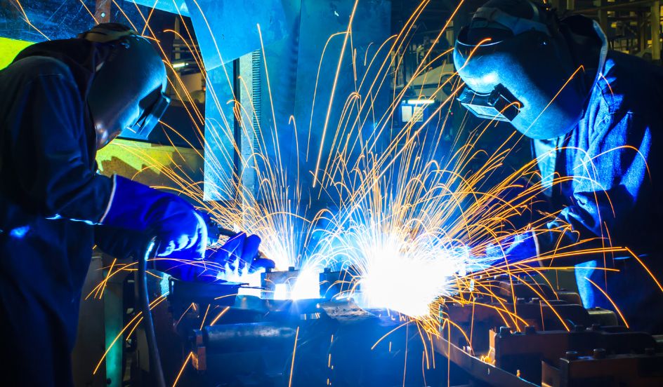 two welders welding with sparks