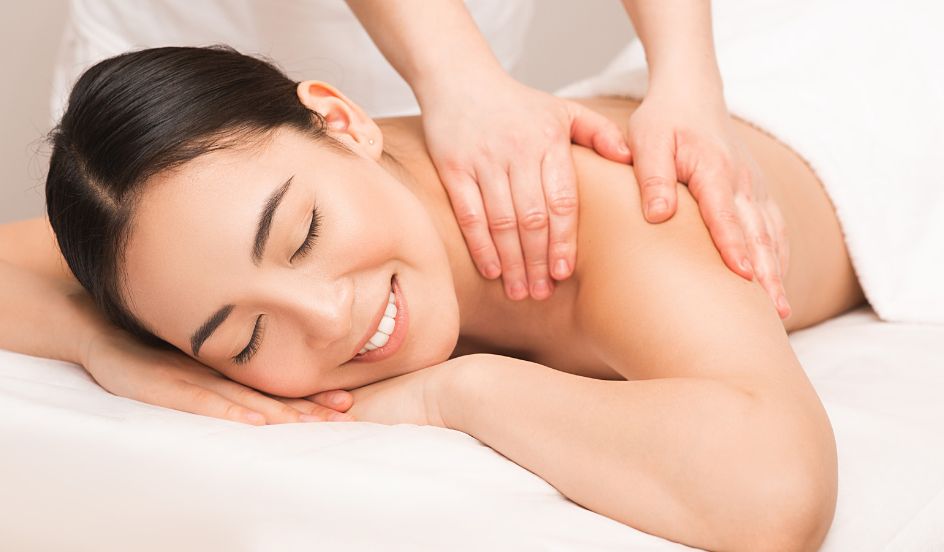 massage therapist massaging female clients back