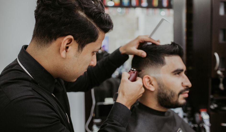 barber cutting male clients hair