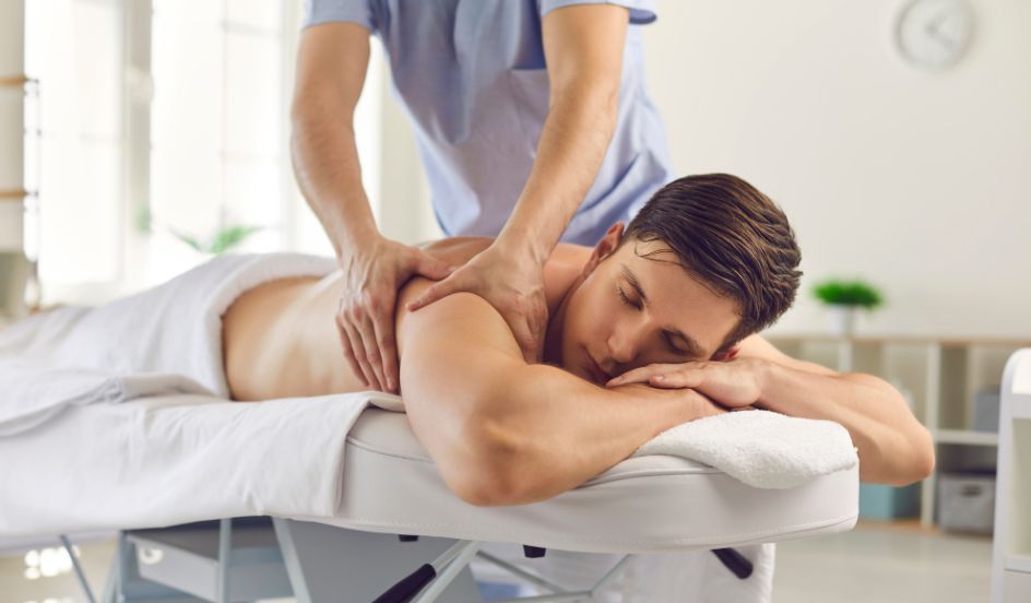 massage therapist massaging male clients back
