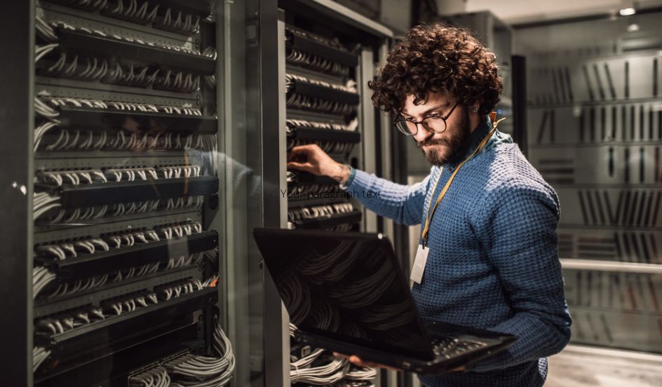 IT Administrator on laptop in server room