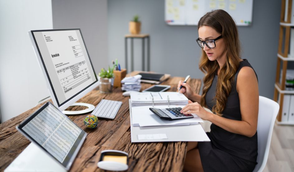 female accountant at desk working on a computer and calculator