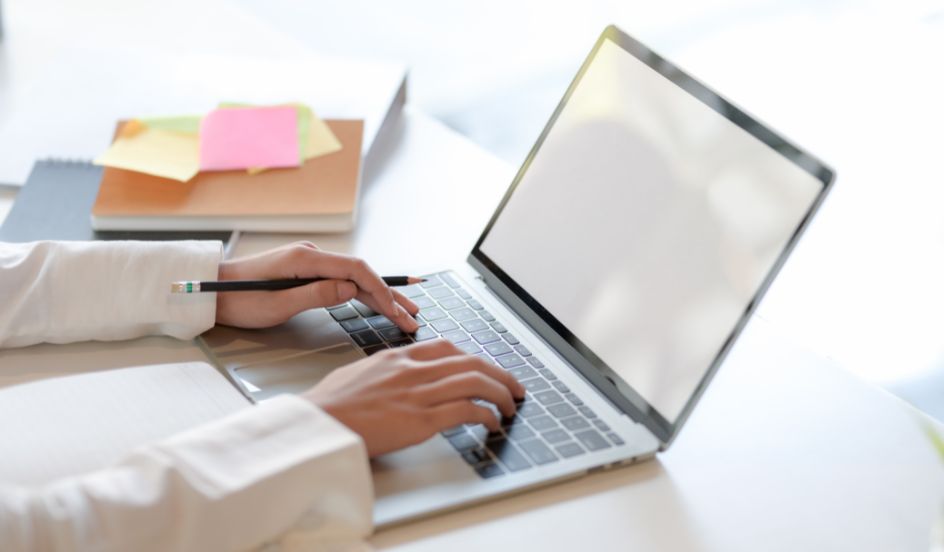 hands typing on keyboard of laptop