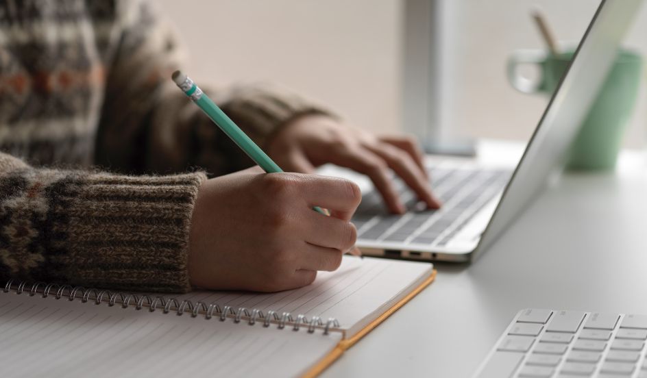 student learning online with laptop and notebook