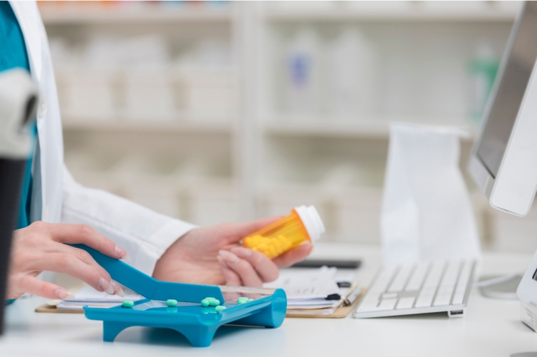 pharmacy technician holding up a bottle of medication