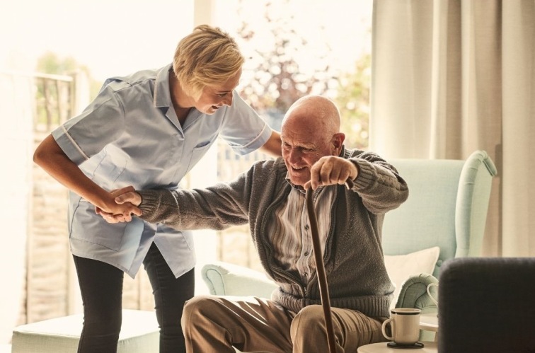 A home support worker assists an elderly man