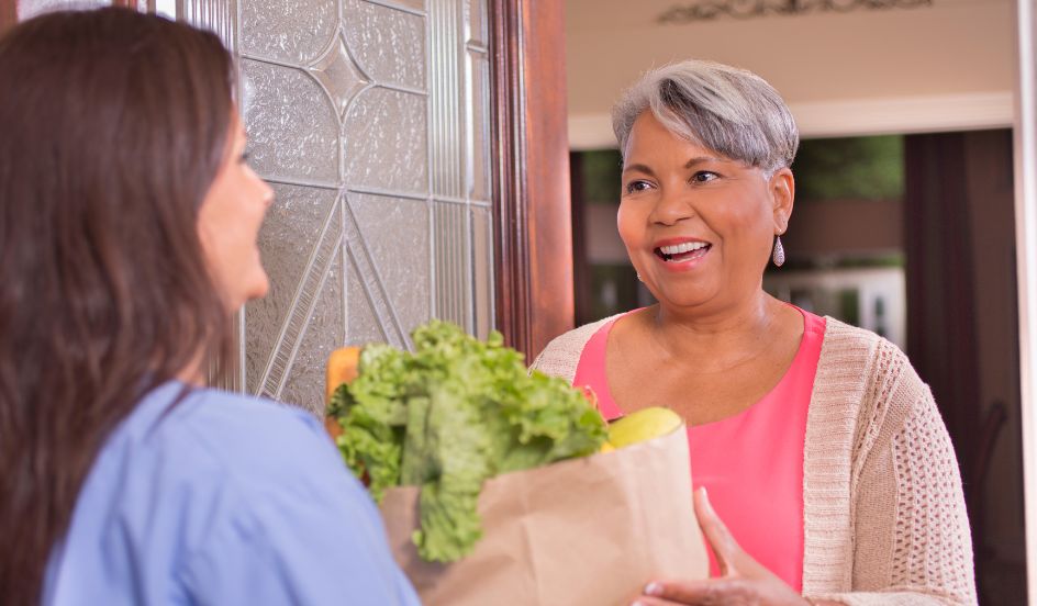 senior receiving groceries from a psw
